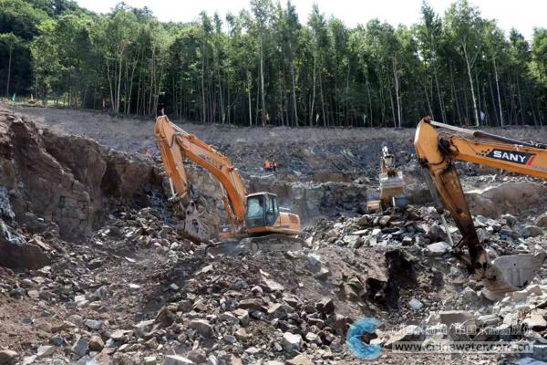 敦化市大川水库枢纽工程施工现场却机械轰鸣、工程车辆在烈日下来回穿梭不停