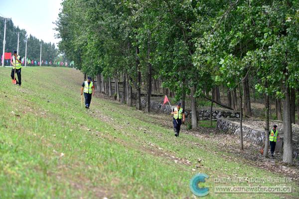 值守人员顶着烈日在堤内护坡上巡查
