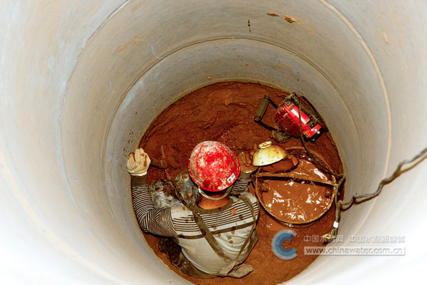 ▲陕西省榆林市横山区殿市镇黑石克村,由区水利局帮扶、村里投资的饮水试验井开始施工。到了五米深度,土壤含水越来越高,土块成了泥水,挖井人穿起雨裤,舀出了沁水。 田娟 摄