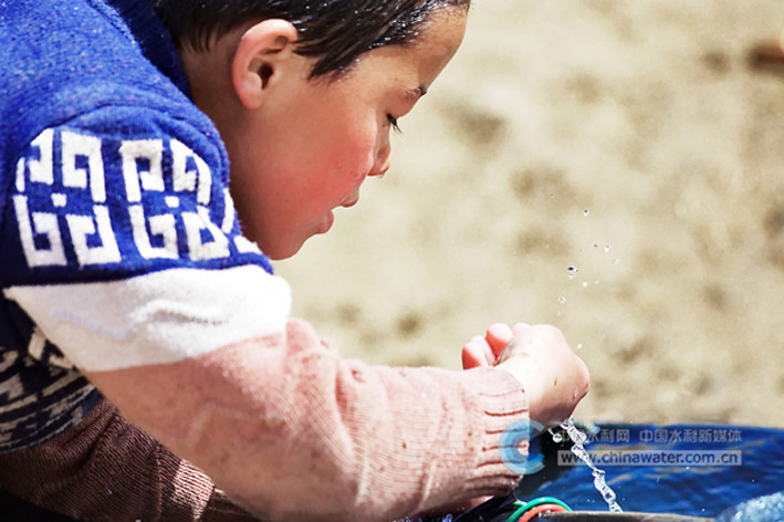 防病改水提质增效工程是解决“不愁吃、不愁穿”的重要举措。马合木提·麦提亚森在昆仑山下、沙漠边缘的小村庄里高兴地用手捧起洁净的水。王忠庆 摄