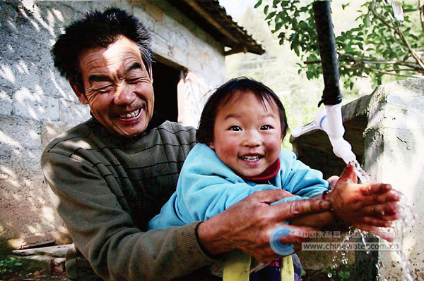清洁甘甜的自来水流进重庆市巫山县千家万户,浸润着山村百姓的心田。巫山县骡坪镇北山村自来水接通后,村民梁佑兵爷孙俩满脸喜悦。马小波 摄